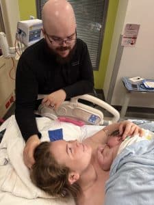 New Parents Holding Newborn in Hospital Room