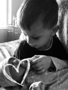 Older brother holding his new baby sister