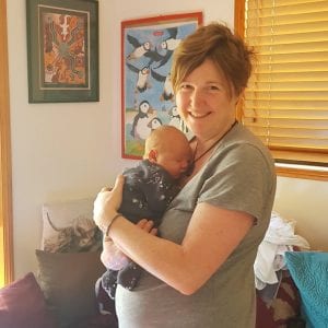 Hypnobirthing Mum Emma Standing holding her newborn baby