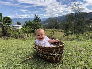 Baby in a basket with beautiful mountain views behind