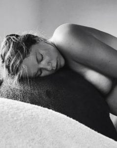 Mother breathing through contractions leaning over a ball