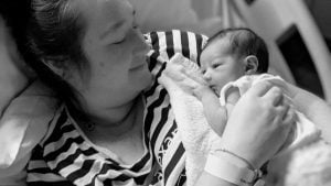 Mum holding new born baby on chest 