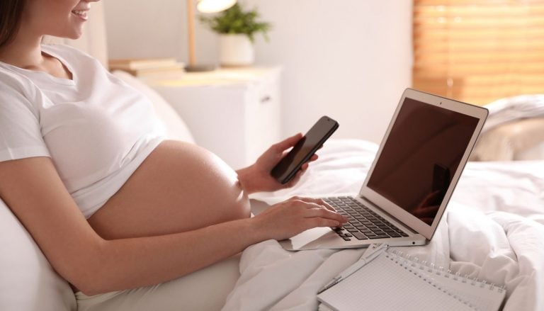 Pregnant Woman Working Bed Home Closeup Maternity Leave Pregnant woman working on bed at home