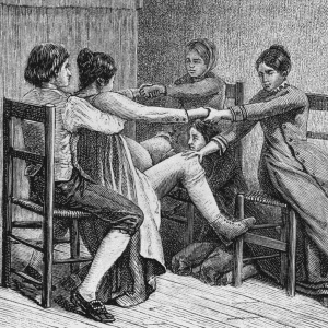 Pioneer birth scene of two women and two men assist during childbirth