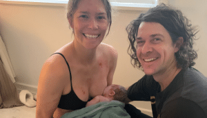 Happy parents smiling with their newborn baby after a natural home birth
