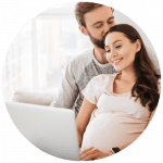 Pregnant couple using laptop